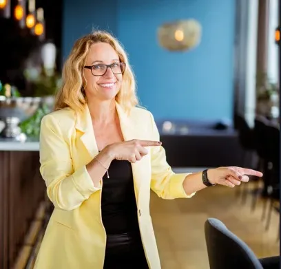 Jennie i gul kavaj pekar glatt åt sidan