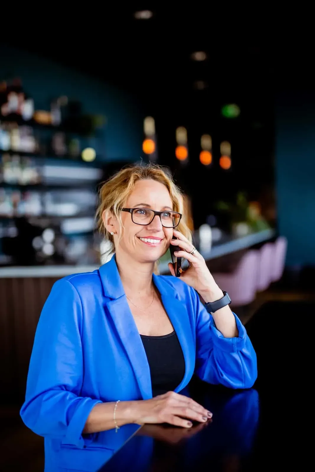 Jennie i blå kavaj pratar i telefon och ler