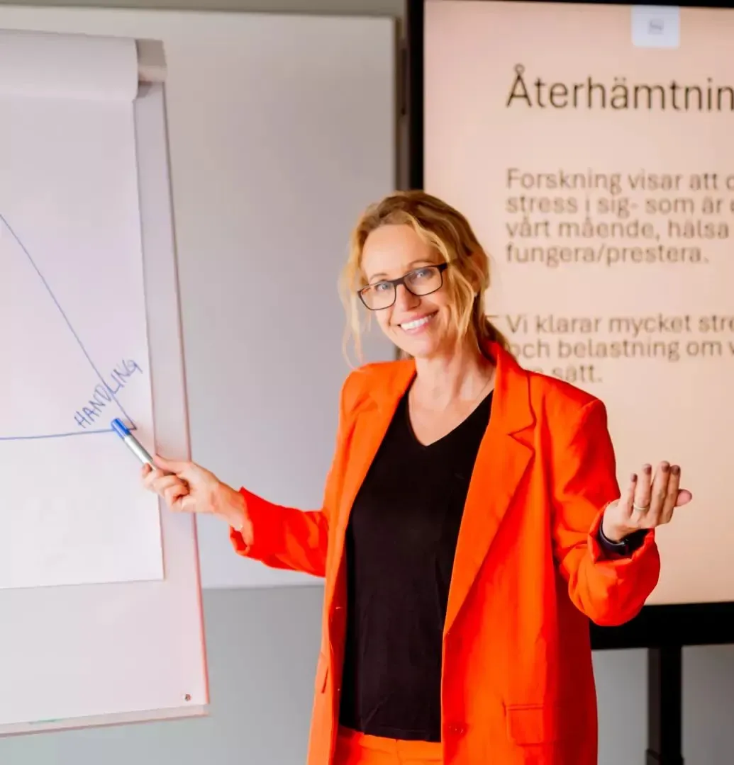 Jennie i orange kavaj föreläser om återhämtning vid ett blädderblock